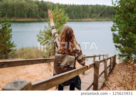 Attractive young woman enjoying fresh air on the lake. Travel, Hiking, nature Attractive young woman enjoying fresh air on the lake. Travel, Hiking, nature 125623931