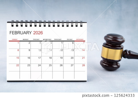 February 2026 desk calendar with judge's gavel on worktable. 125624333