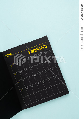 February 2026 Black calendar opening on blue background. 125624356
