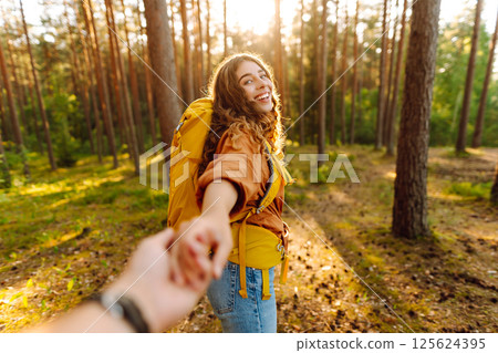 Traveling together. Happy woman holds the boyfriend's hand and walking on the forest. Vacation Traveling together. Happy woman holds the boyfriend's hand and walking on the forest. Vacation 125624395
