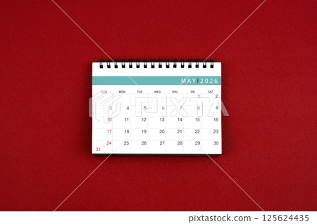 May 2026 desk calendar on red background in the middle top view. May 2026 desk calendar on red background in the middle top view. 125624435
