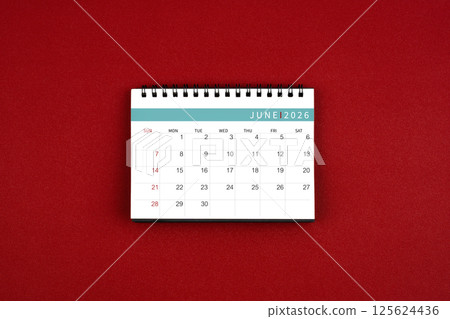 June 2026 desk calendar on red background in the middle top view. 125624436