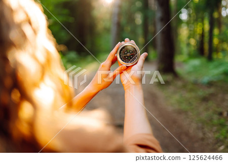 Hands of woman holding navigational compass. Female traveler holding compass in hands 125624466