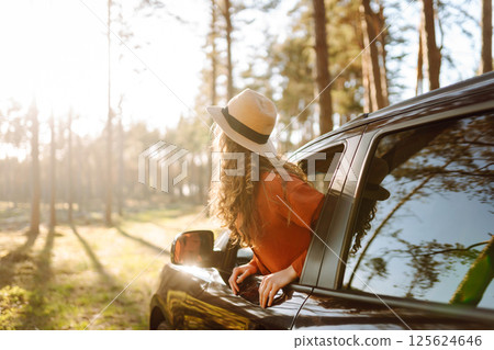 Young woman leaning out of the car window enjoying nature. Road trips summer holidays. Young woman leaning out of the car window enjoying nature. Road trips summer holidays. 125624646