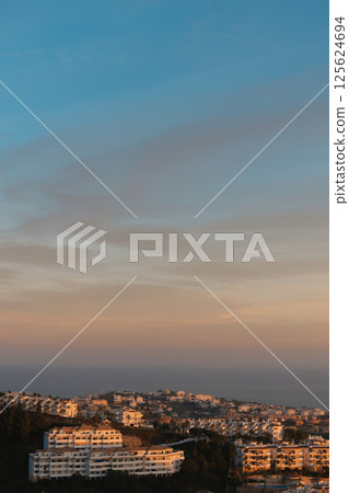 Golden hour light over Mediterranean hillside town in Costa del Sol 125624694