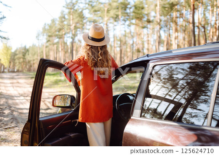 Stopping during a car trip. Young woman enjoying nature. Journey by car. Lifestyle, travel, tourism 125624710