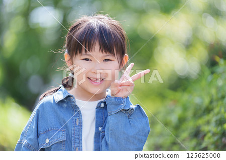 Smiling child making a peace sign 125625000