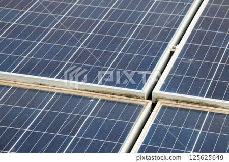 Solar panels with visible dirt and dust mounted on a rooftop. Represents the importance of maintenance for sustainable and efficient renewable energy usage. 125625649