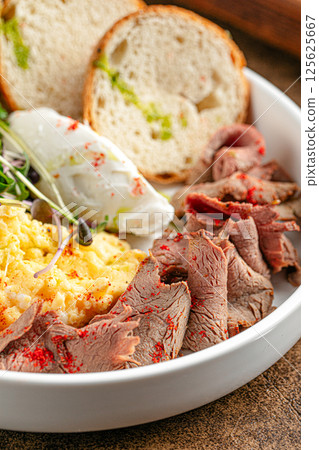Portion of with scrambled eggs and pastrami 125625667