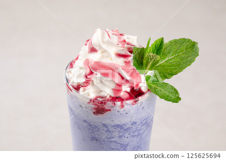 Portion of blueberry milkshake with whipped cream Portion of blueberry milkshake with whipped cream 125625694