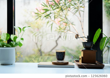 Coffee glass cup and plant pot, coffee grinder by the window Coffee glass cup and plant pot, coffee grinder by the window 125626060