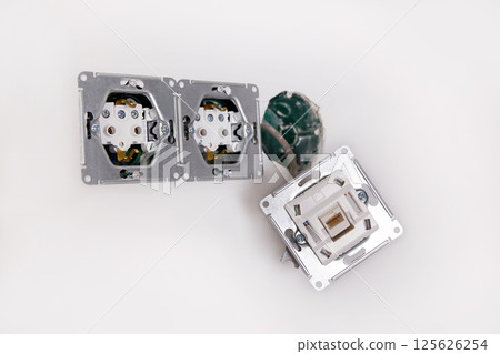 A close-up view of an electrical outlet being installed into a wall. A close-up view of an electrical outlet being installed into a wall. 125626254