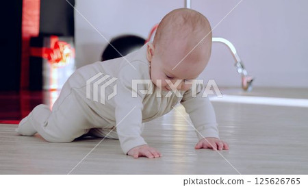 Baby boy moves across floor innocent curiosity leading him on quiet adventure of discovery. Crawling across room little boy begins to explore world innocence and amazement of childhood. Baby boy moves across floor innocent curiosity leading him on quiet adventure of discovery. Crawling across room little boy begins to explore world innocence and amazement of childhood. 125626765