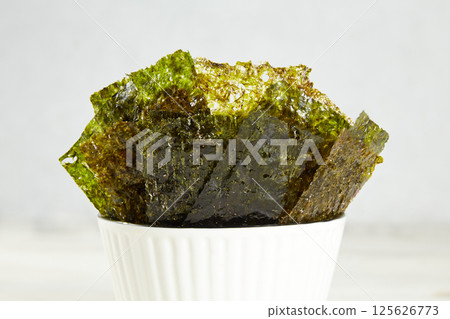 Crispy nori seaweed on bowl. Traditional Japanese dry seaweed sheets. 125626773