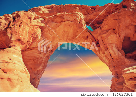 Arch in the rock against colorful sunset sky. Desert nature landscape. Timna Park. Israel 125627361