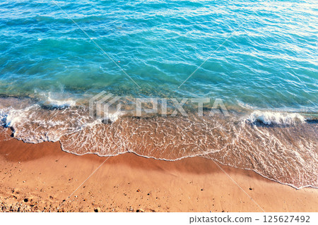 Waves roll on the sandy beach. Natural background Waves roll on the sandy beach. Natural background 125627492