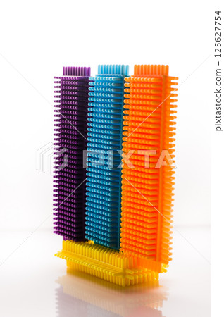 Three colored parts of a children's construction set on a white background. Puzzle for young childre. Three colored parts of a children's construction set on a white background. Puzzle for young childre. 125627754