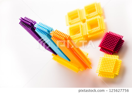 Bright parts of the construction toy form abstract objects. The children's building set appears lively and energetic against the light background.  125627756