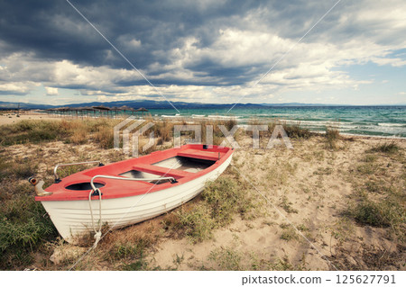 Seascape with dramatic sky. Boat on the beach Seascape with dramatic sky. Boat on the beach 125627791