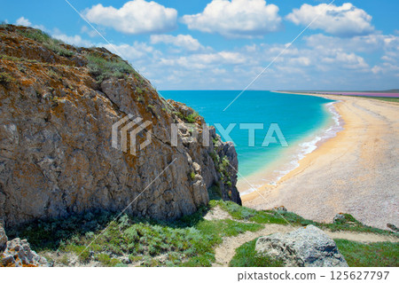 Rocky seascape. Panoramic view at sandy beach from mountain. 125627797