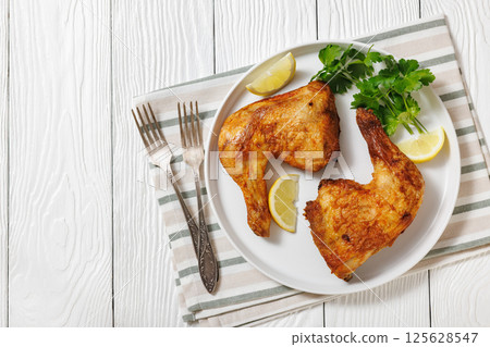roast chicken legs with crispy skin on a plate roast chicken legs with crispy skin on a plate 125628547