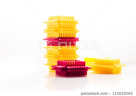 The colorful children's construction set combines elements of various shapes and sizes. The play kit is arranged on a white background, highlighting the contrast of the parts. 125628565