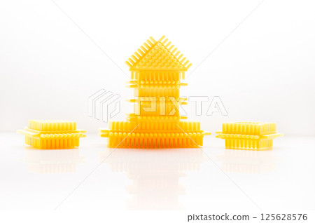 The elements of the children's construction toy harmonize well with the background color. The plastic building blocks of the play set attract with their shape and color.  125628576