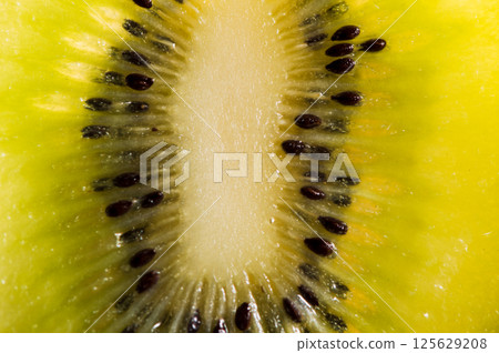 The kiwi piece stands out brightly against the solid background. The green kiwi is shown in detail, highlighting its juiciness. The kiwi piece stands out brightly against the solid background. The green kiwi is shown in detail, highlighting its juiciness. 125629208
