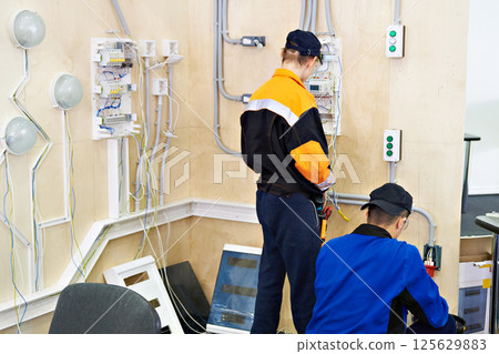 Electrician makes wiring for lighting 125629883