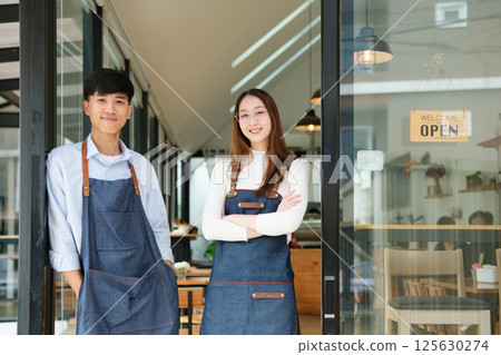 Small business owners standing together inside cozy coffee shop 125630274