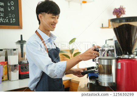 Male barista making coffee in a coffee machine. Food and drink concept. Male barista making coffee in a coffee machine. Food and drink concept. 125630299