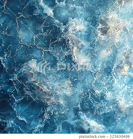A captivating abstract display of a frozen, cracked ice surface with varying shades of blue. 125630486