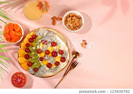 Fruit salad with soft grain cottage cheese, yogurt, dragon fruit, kiwi, mango, oranges, nuts, grapes and juice, Healthy light breakfast with ingredients. Diet healthy lifestyle advertisement, 125630792