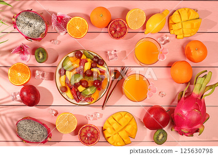 Fruit kitchen background with ingredients for making salad. Dragon fruit, mango, kiwi, orange, nuts and dried apricots, exotic fruits for a healthy lifestyle, advertising banner for a cafe, 125630798