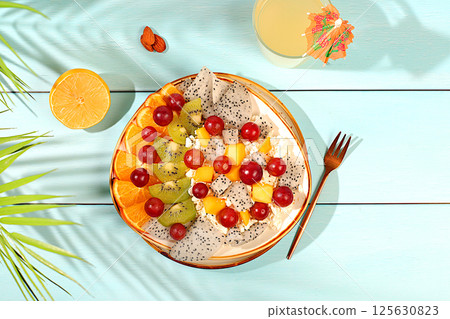 Fruit salad with soft grain cottage cheese, yogurt, dragon fruit, kiwi, mango, oranges, nuts, orange juice and grapes. Healthy light breakfast with ingredients, diet healthy lifestyle advertisement, Fruit salad with soft grain cottage cheese, yogurt, dragon fruit, kiwi, mango, oranges, nuts, orange juice and grapes. Healthy light breakfast with ingredients, diet healthy lifestyle advertisement, 125630823