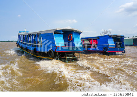 Wooden tourist ferries traffic in the Mekong river delta, Vietnam 125630941