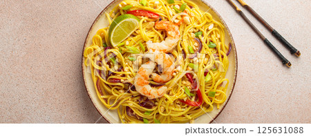 Pad thai noodles with shrimps, peanuts and lime on a plate, traditional dish of Thailand Pad thai noodles with shrimps, peanuts and lime on a plate, traditional dish of Thailand 125631088