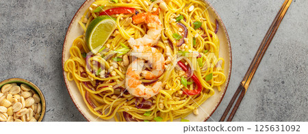 Pad thai noodles with shrimp, peanuts and lime on grey background, dish of Thailand 125631092