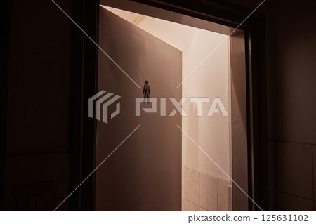 Toilet door left ajar, men's toilet sign 125631102