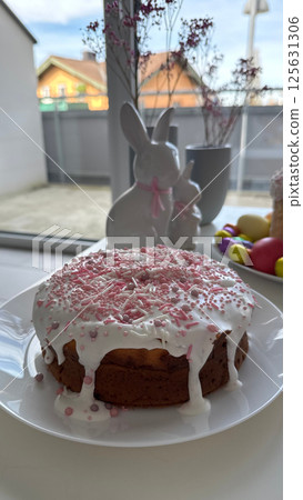 Deliciously decorated cake with pink icing and sprinkles on a white plate Deliciously decorated cake with pink icing and sprinkles on a white plate 125631306