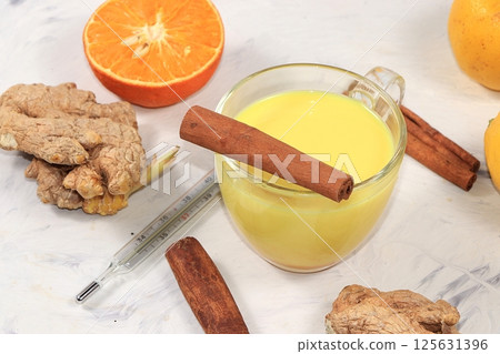 Traditional turmeric latte with ginger root, cinnamon sticks, honey, thermometer, spices for Ayurvedic medicine. Alternative medicine concept, has anti-inflammatory effect, Traditional turmeric latte with ginger root, cinnamon sticks, honey, thermometer, spices for Ayurvedic medicine. Alternative medicine concept, has anti-inflammatory effect, 125631396