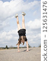 Little girl stands on her hands upside down 125631476