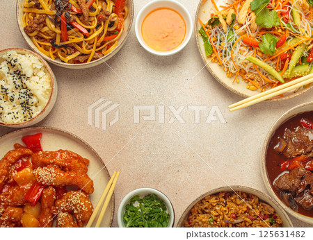 Variety of Chinese food dishes top view on table with chopsticks forming a frame with space for text, light beige background, cuisine of China Variety of Chinese food dishes top view on table with chopsticks forming a frame with space for text, light beige background, cuisine of China 125631482