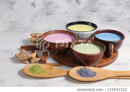 An assortment of colorful latte Japanese tea, matcha green, blue, pink moon milk, golden milk, ginger and cinnamon, top view. A fashionable healthy drink has anti-inflammatory properties. 125631522