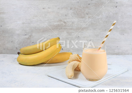 Indian banana yogurt lassi with spices, on the old grunge background, probiotic fermented milk drink, natural diet food, helps to lose weight and reduce body weight, selective focus Indian banana yogurt lassi with spices, on the old grunge background, probiotic fermented milk drink, natural diet food, helps to lose weight and reduce body weight, selective focus 125631564