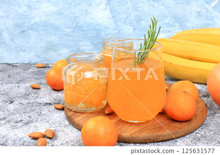 Tangerine juice and jam with honey and banana pieces, a healthy natural food for the flu and colds. A selection of fresh fruits with vitamin C to strengthen the immune system. Selective focus. 125631577