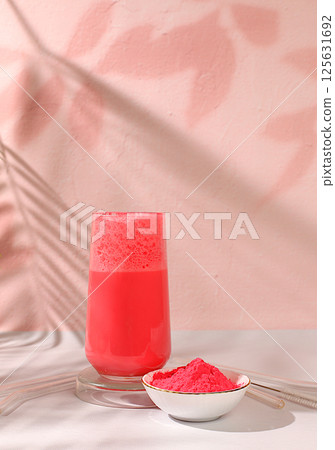 Pink matcha tea latte with milk on elegant kitchen sunny background with palm leaves and matcha powder. Traditional indian drink rich in antioxidants used for weight loss and treatment, selective 125631692