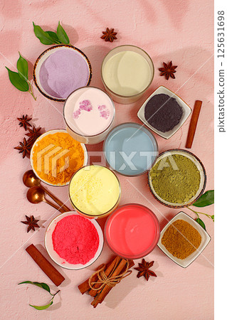 Various matcha tea lattes with milk on light background and matcha powder in cups. Traditional Indian trendy drink rich in antioxidants, used for weight loss and treatment, selective focus 125631698