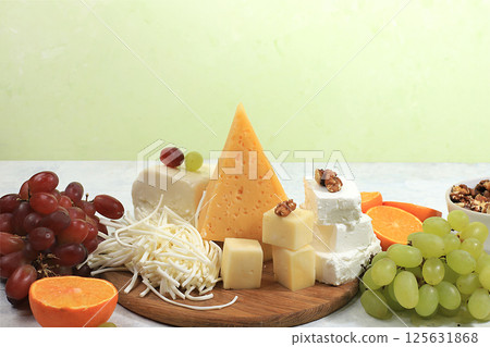 Assortment of different varieties of cheeses, grapes and nuts, fruits, the basis of the French diet, healthy and natural food selection, advertising card or invitation to a cafe, shop, menu, selective 125631868