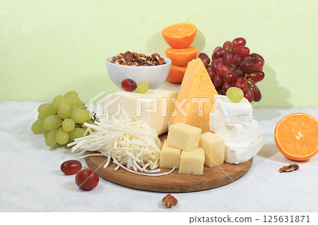 Assortment of different types of cheeses, grapes and nuts, healthy and natural food selection, advertising card or invitation for cafe, shop, menu, selective focus, place for text Assortment of different types of cheeses, grapes and nuts, healthy and natural food selection, advertising card or invitation for cafe, shop, menu, selective focus, place for text 125631871